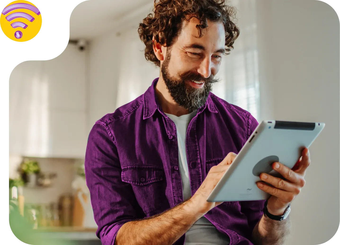 Homem sorrindo enquanto usa um tablet em casa