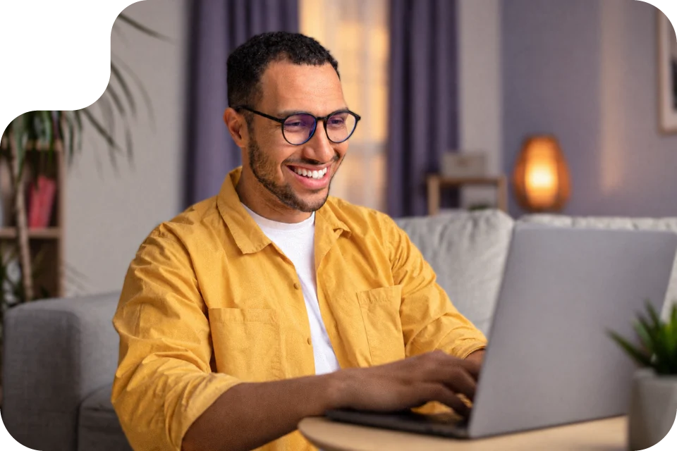 Homem feliz mexendo no notebook